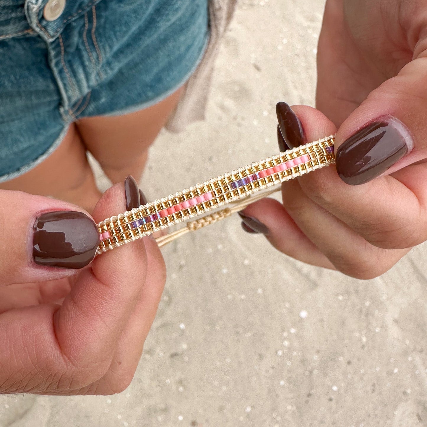 Close-up of hands holding a decorative ribbon with a blurred background
