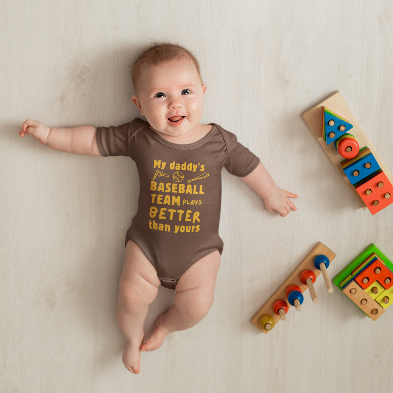 Baby wearing a brown and yellow  baseball bodysuit