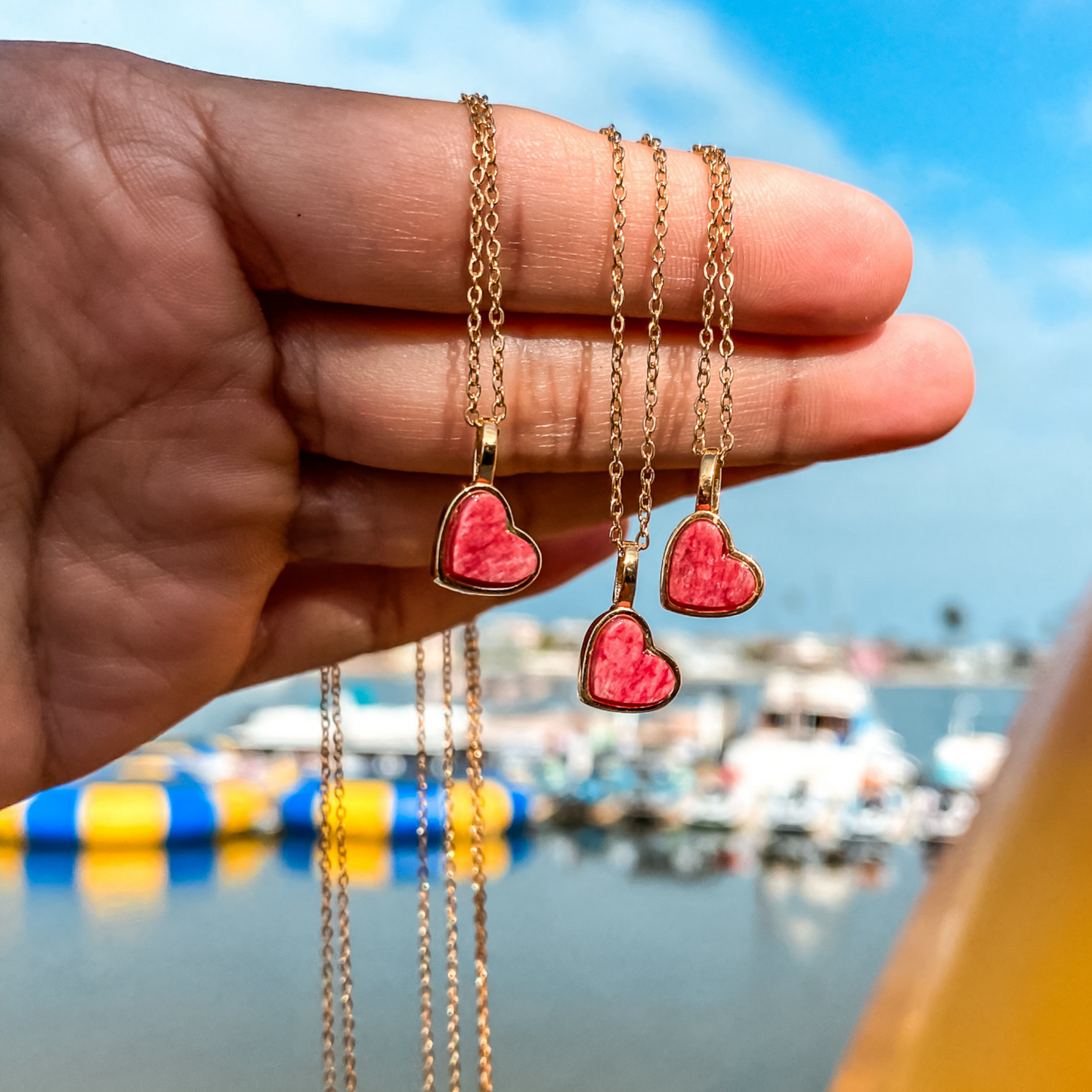 Yellow gold charm necklace with a heart shaped red feldspar natural gemstone. Made by Born to Rock. Online jewelry store based in San Diego California
