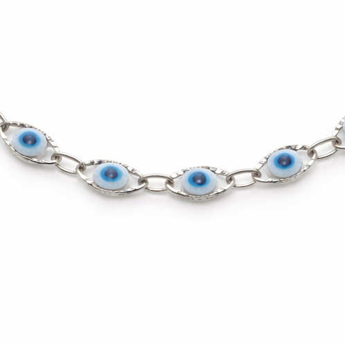 Silver bracelet with eye-shaped white and blue beads on a white background