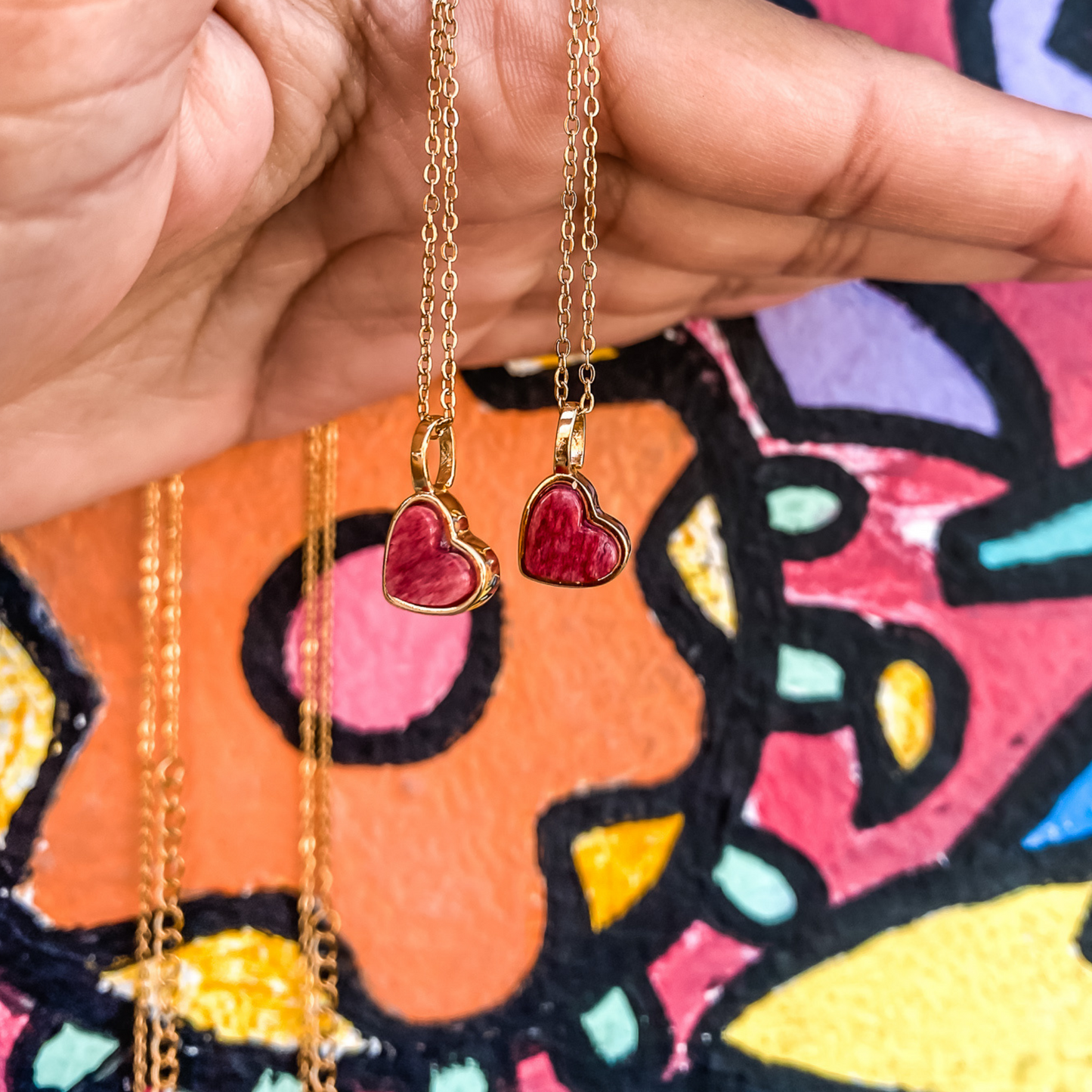 Yellow gold charm necklace with a heart shaped red feldspar natural gemstone. Made by Born to Rock. Online  jewelry store based in San Diego California