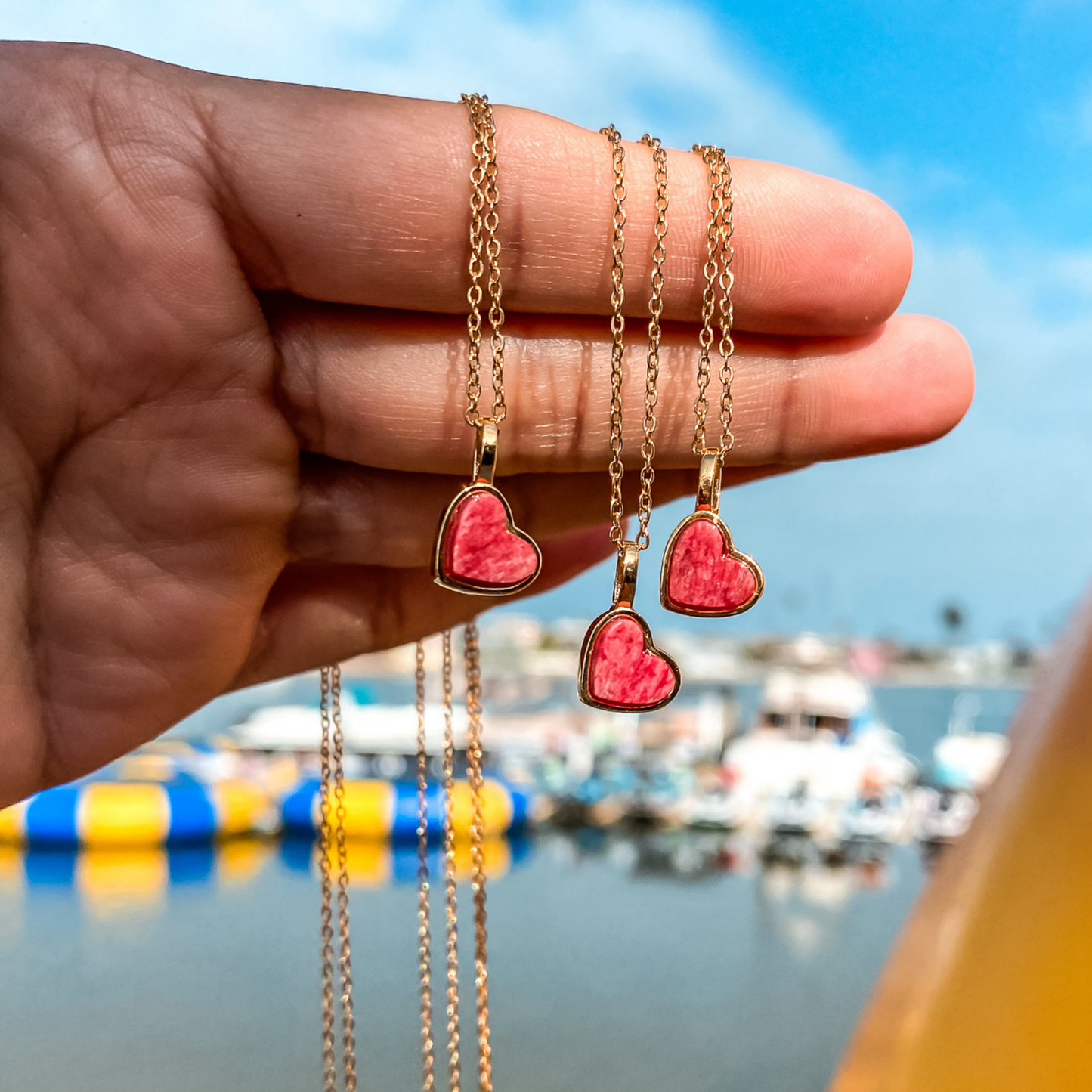 Yellow gold charm necklace with a heart shaped red feldspar natural gemstone. Made by Born to Rock. Online  jewelry store based in San Diego California