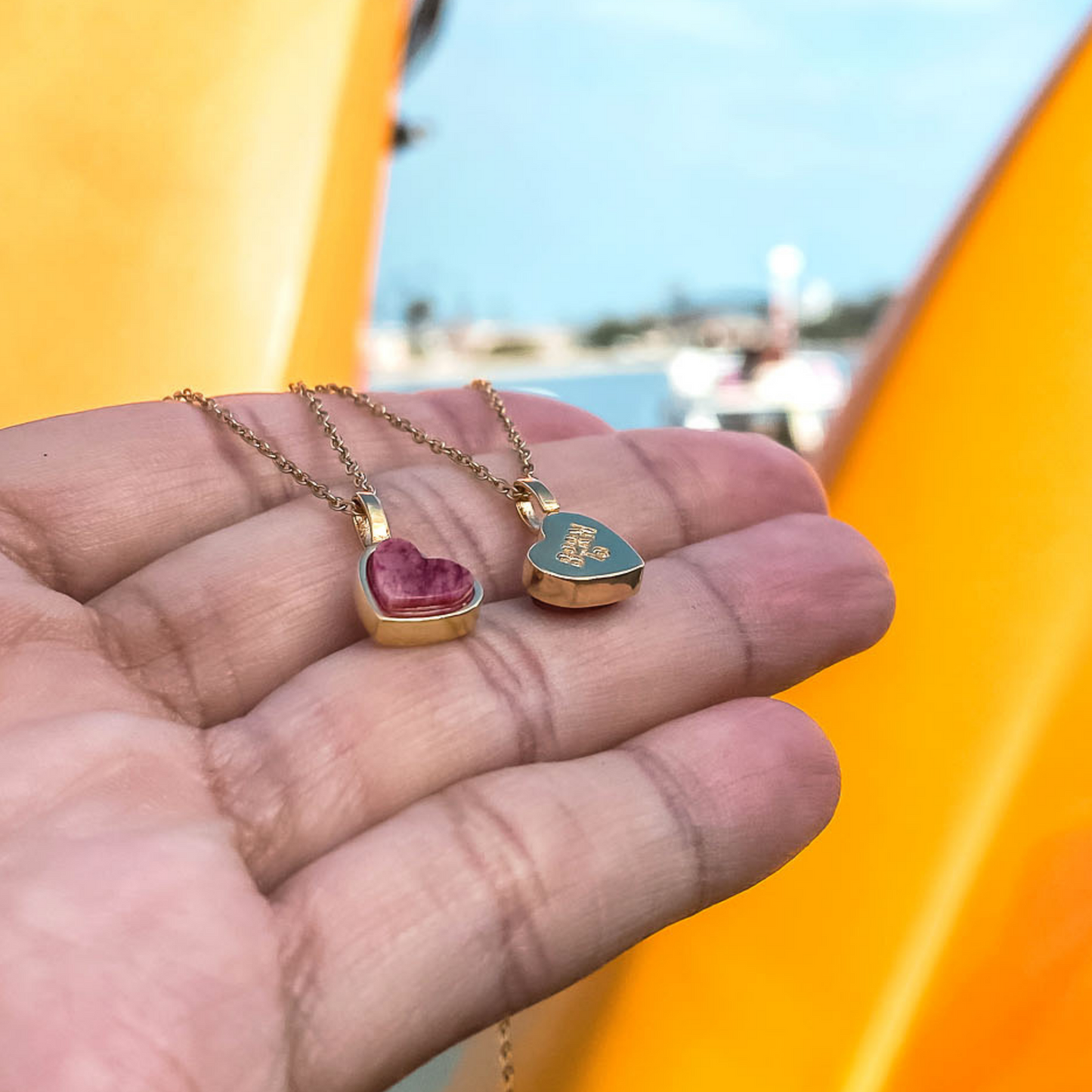 Yellow gold charm necklace with a heart shaped red feldspar natural gemstone. Made by Born to Rock. Online  jewelry store based in San Diego California